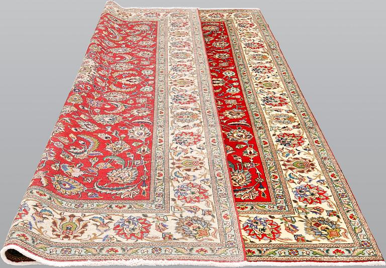 A signed Tabriz carpet, ca 336 x 223 cm.