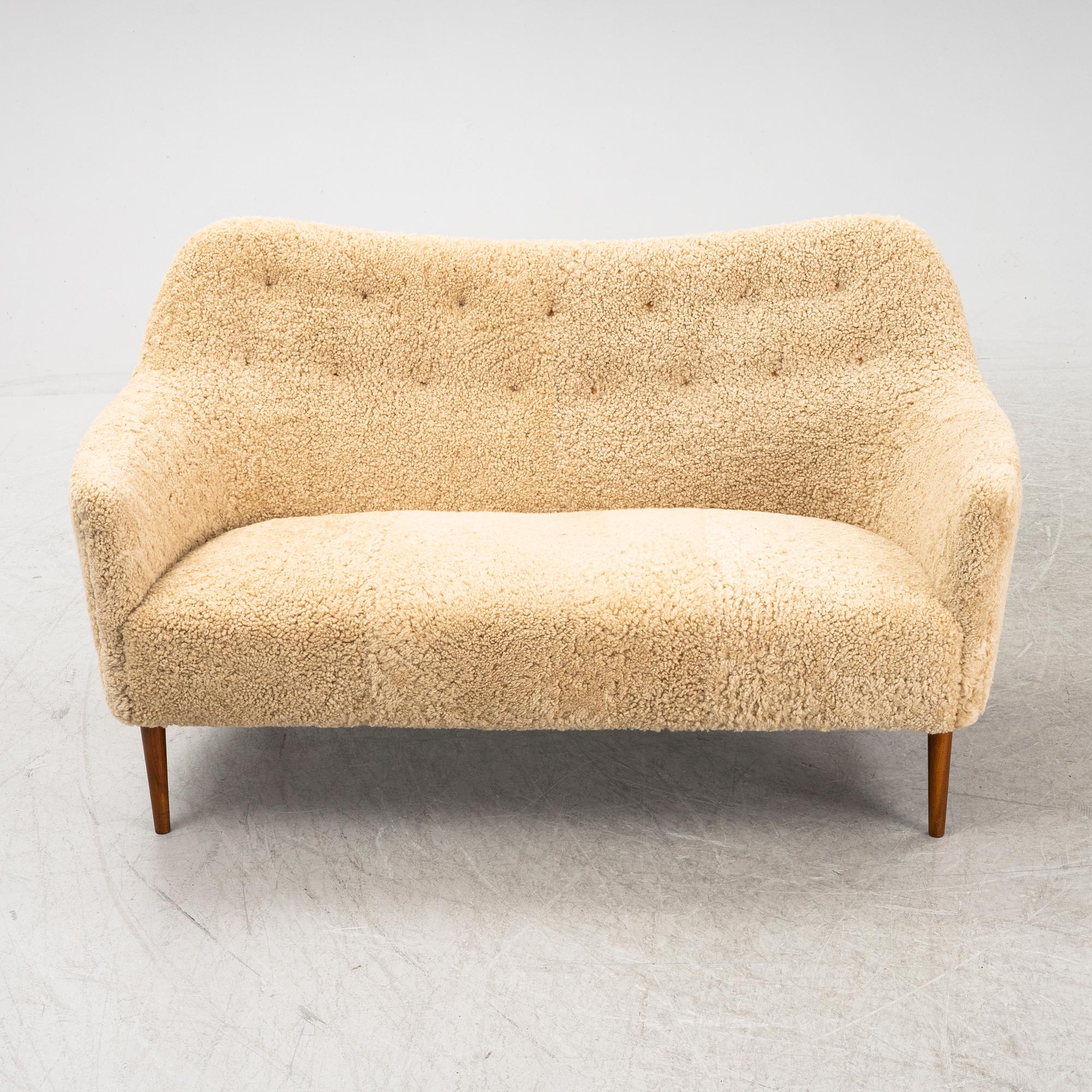 A mid 20th Century sofa with teak legs and new sheepskin upholstery, possibly by Carl Brorup, Slagelse, Denmark.