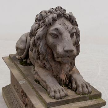 A SCULPTURE/ DECOR-ELEMENT, a lion on a plint, artificial stone, empire-style, late 1900s.