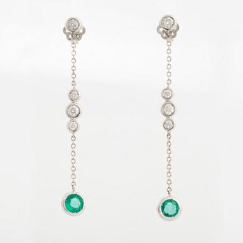 A pair of 18K white gold earrings set with faceted emeralds.
