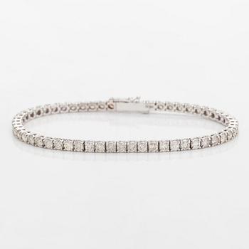 A 14K white gold tennis bracelet set with brilliant-cut diamonds.