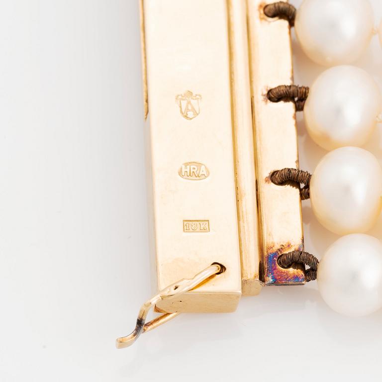 A nine strand cultured fresh water pearl bracelet with  clasp in 18K gold.