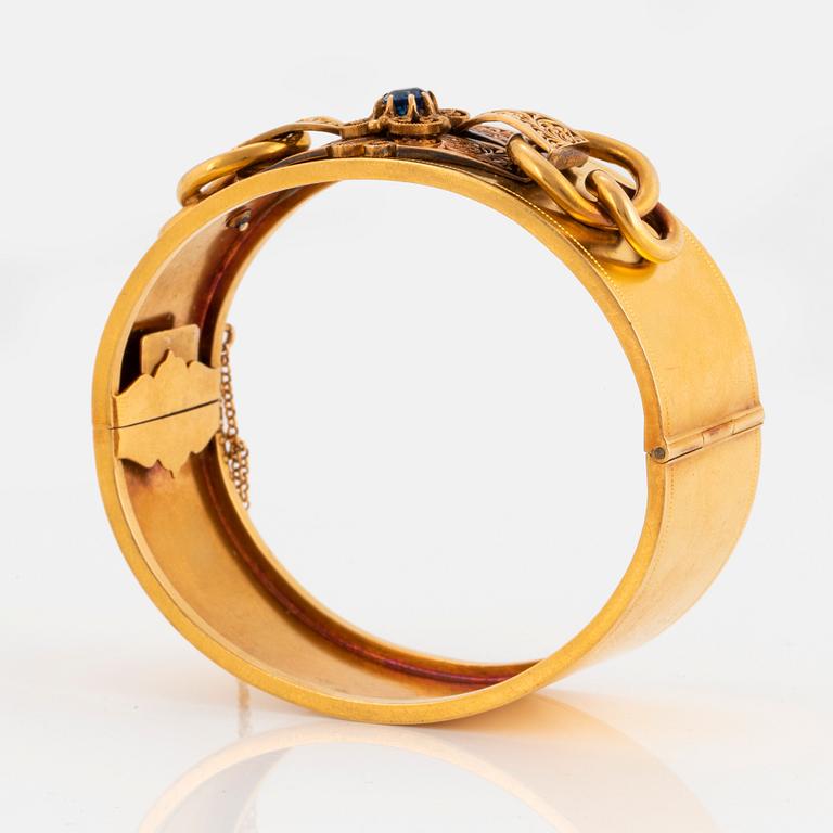 Armring 18K guld med en fasettslipad safir.