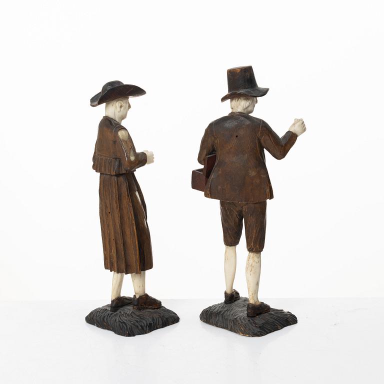 A pair of German carved bone and limewood figures by a follower of Simon Troger, early 18th century.
