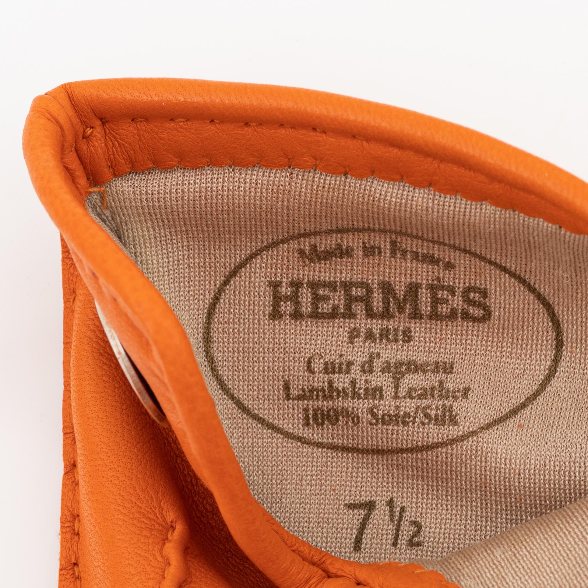 Hermès, a pair of orange kidskin and lambskin gloves, french size 7 1/2.