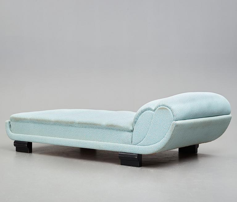 ART DÉCO, an upholstered daybed on shaped black lacquered wooden legs, 1920's-30's.