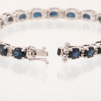 An 18K white gold bracelet set with oval faceted sapphires and round brilliant-cut diamonds.