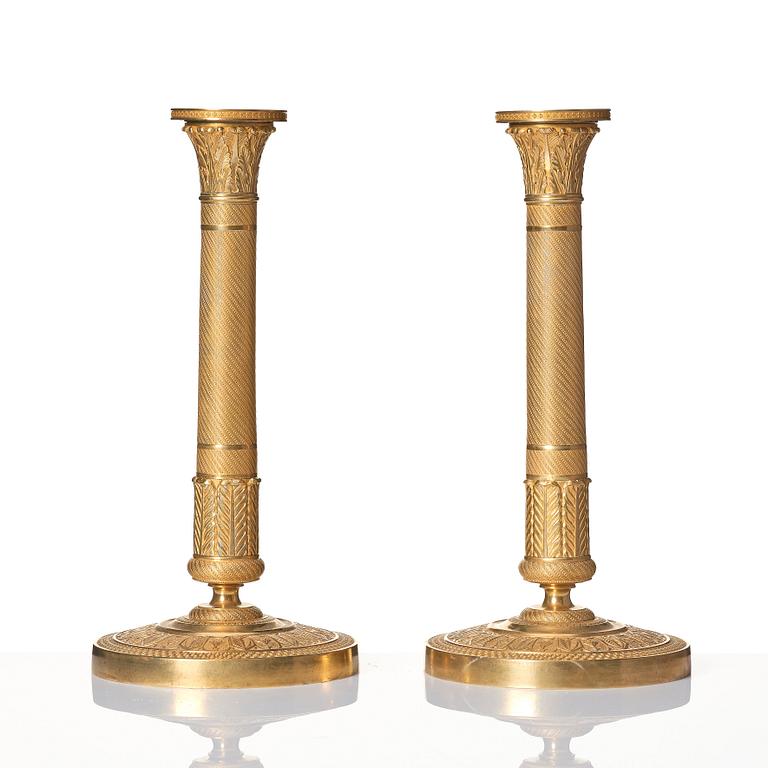 A pair of French Empire ormolu candlesticks, early 19th century.