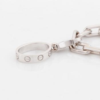 An 18K white gold Cartier "Spartacus" bracelet with two charms.