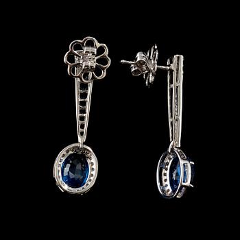 A pair of sapphire and diamond earrings. Sapphire total carat weight 5.63 cts, diamond total carat weight 0.62 ct.