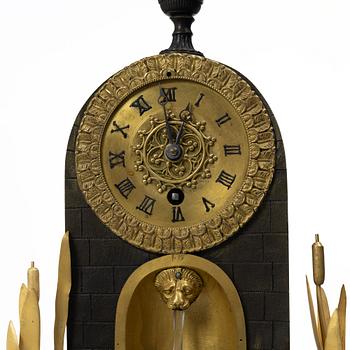 A French Charles X ormolu and patinated bronze mantel clock, ca 1820's.