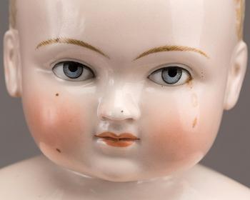 A PORCELAIN "FROZEN CHARLIE" DOLL, from around 1900.