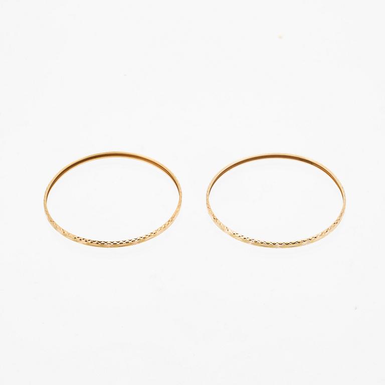 A pair of 18K gold bracelets for children.