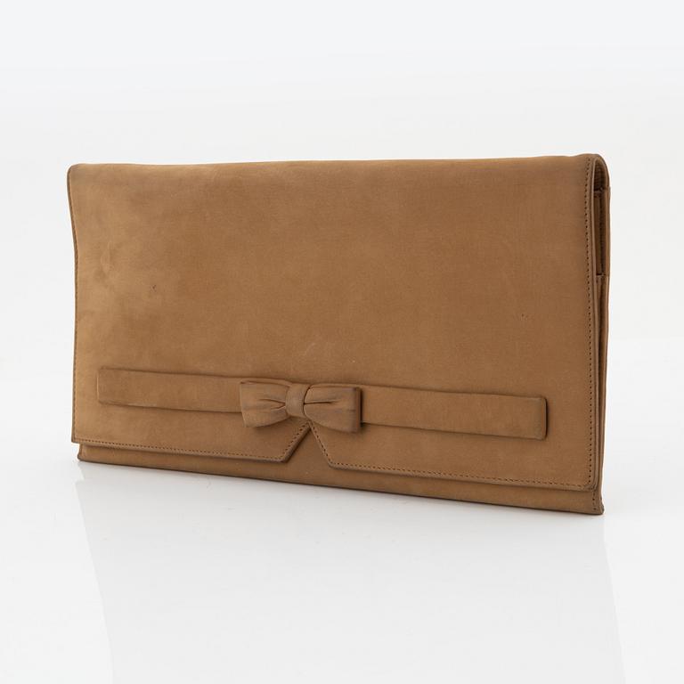 Christian Dior, a tan leather clutch.