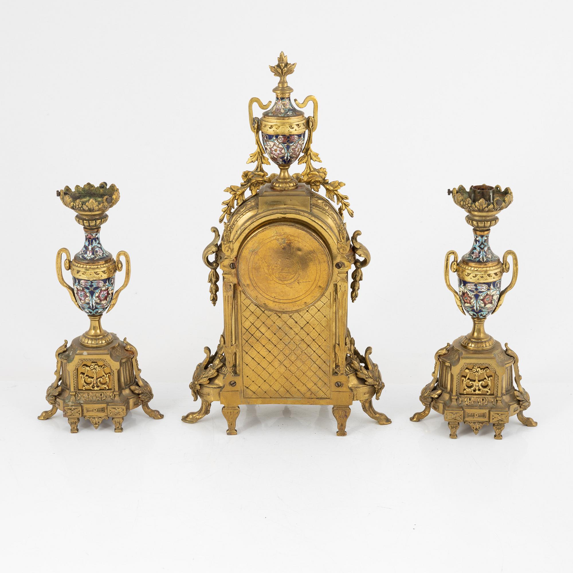 A set of two Louis XVI-style candle sticks and a mantle clock, late 19th century.