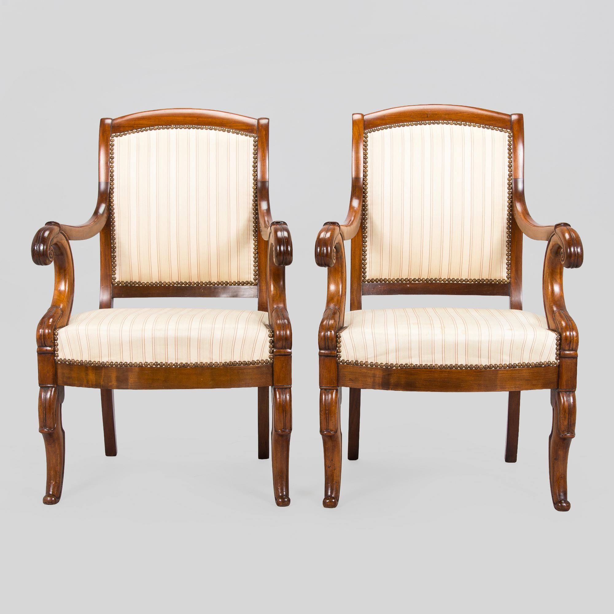 A pair of French open-arm chairs, first half of the 19th century.