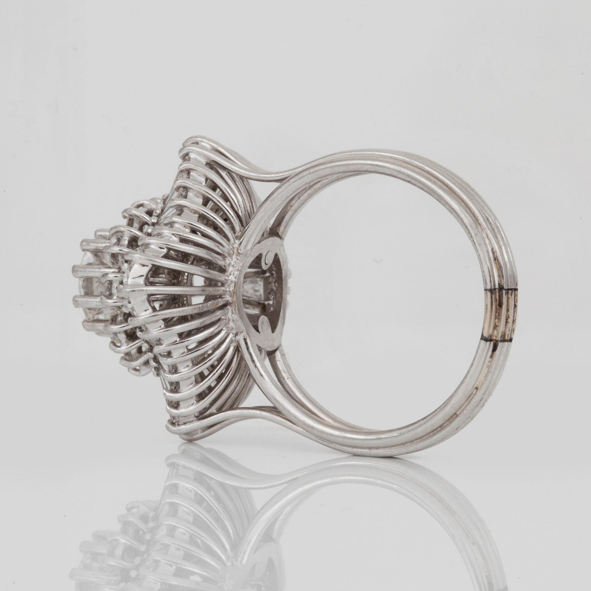 A brilliant- and trapezoid-cut diamond ring. Center diamond circa 1.10 cts and surrounding diamonds circa 1.00 ct.