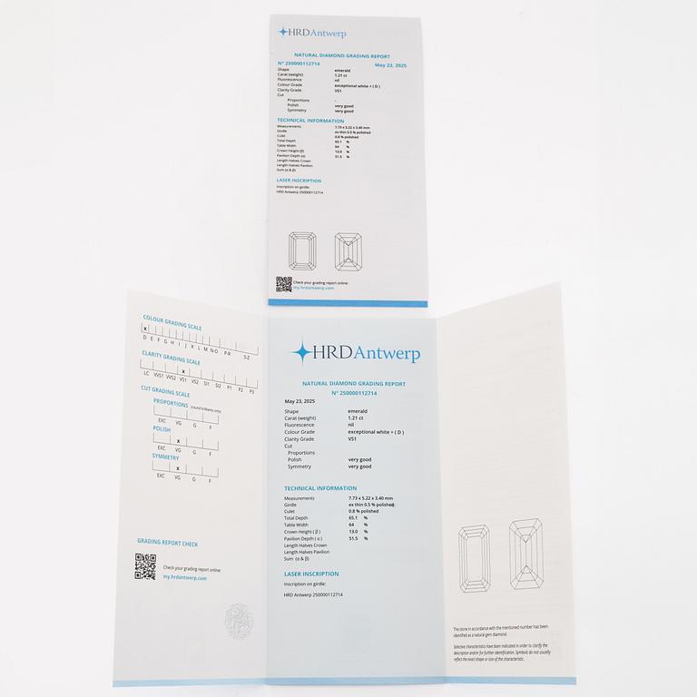 An 18K white gold ring set with an emerald-cut diamond and two step-cut emeralds.