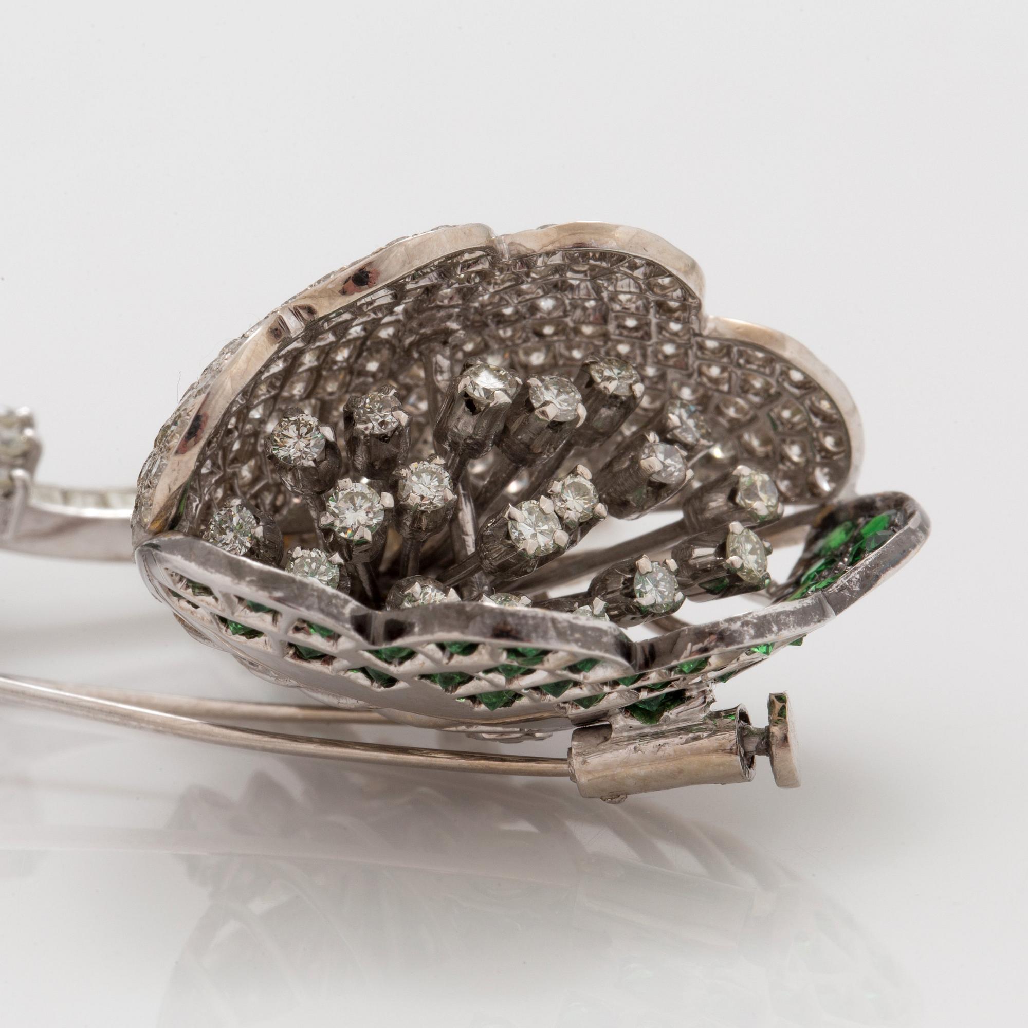 A tsavorite garnet and brilliant cut diamond clip brooch with floral motif.