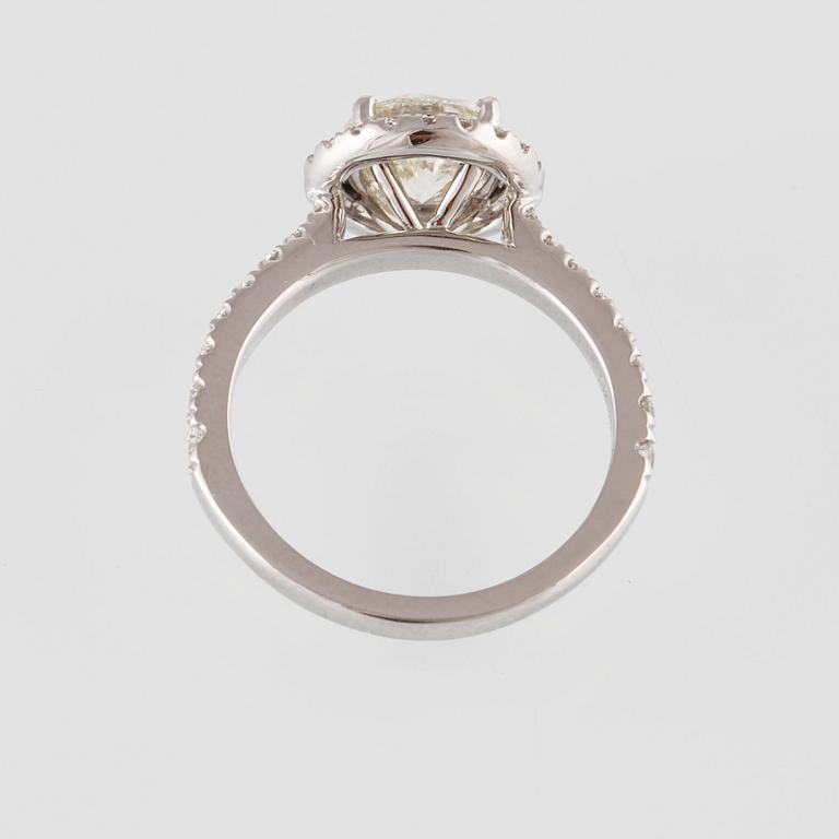 RING, 18K vitguld med en briljantslipad diamant 1.44 ct samt små briljantslipade diamanter 0.50 ct. Vikt 4,6 gram.