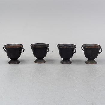 A set of four cast iron garden urns, 20th century.