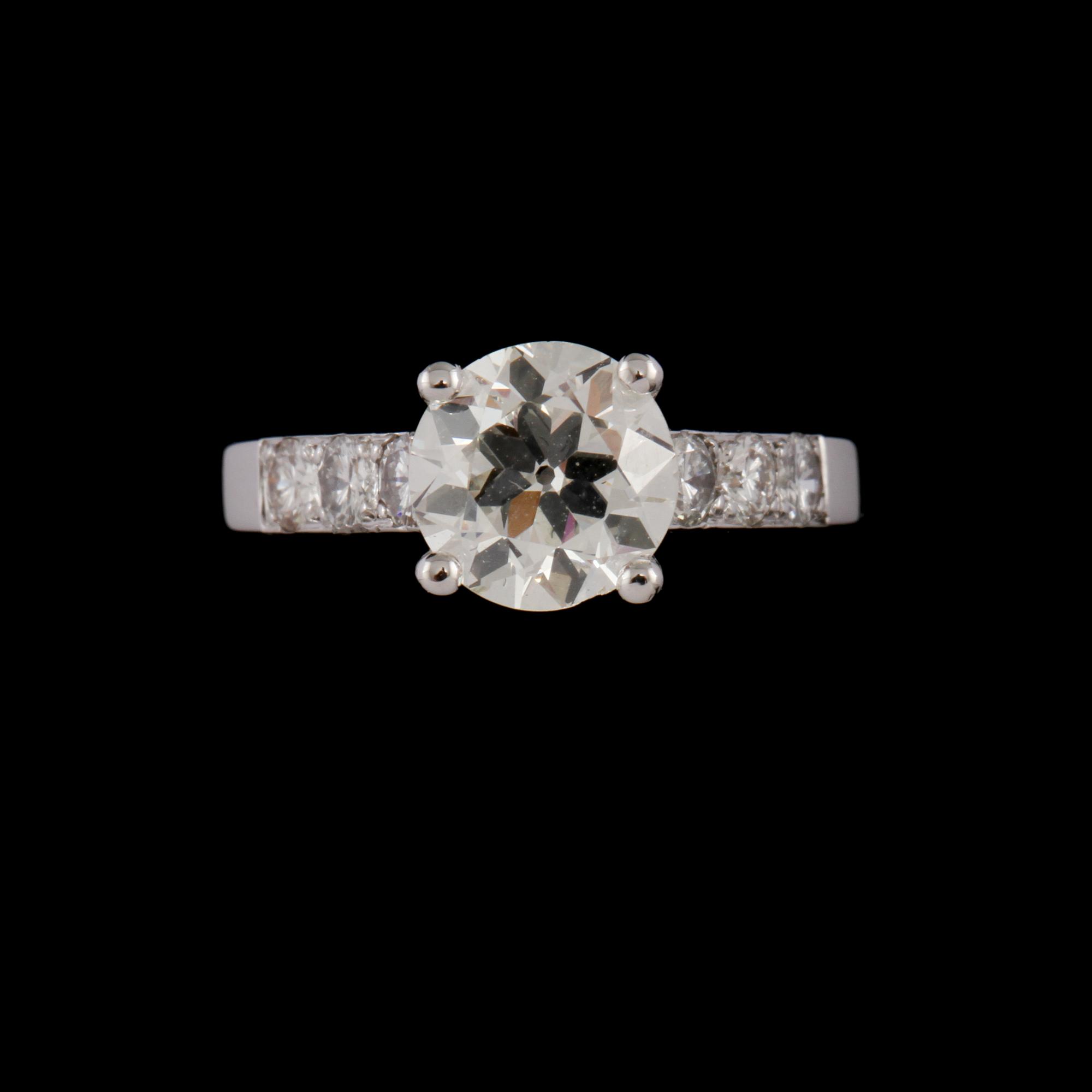 RING, 14k vitguld med äldre briljantslipad diamant, 1.61 ct samt 6 mindre briljantslipade diamanter. Vikt 4 g.