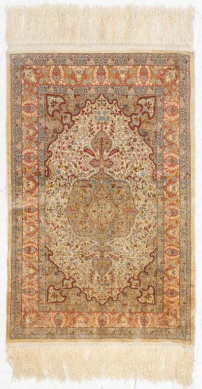 A silk Hereke rug, c. 85 x 55 cm.