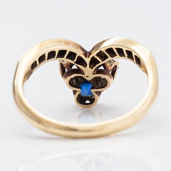 A 14K gold ring with a synthetic sapphire, radiant-cut diamonds ca. 0.28 ct in total and rose cut diamonds.