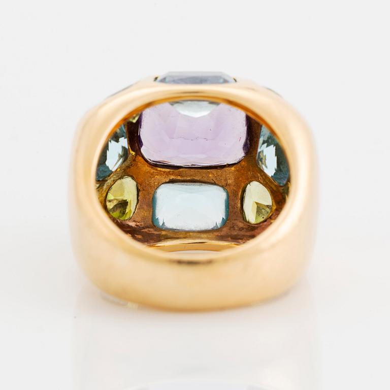 An 18K gold ring set with faceted amethyst, peridot and aquamarine.