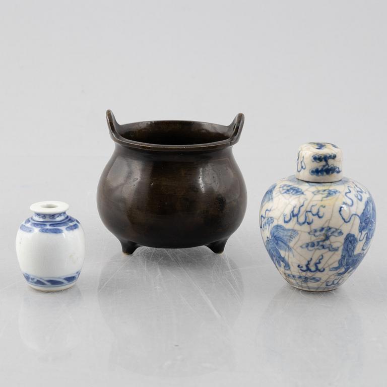 A Chinese bronze tripod censer and two miniature porcelain urns, late Qing dynasty/around 1900.