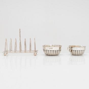 Sterling salt cellar, sugar bowl and creamer, Scotland and Sheffield; silver tea strainer, Turku, and plated toast rack.