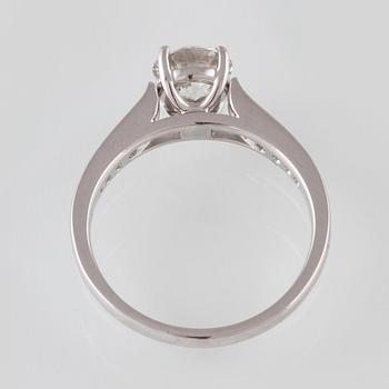 RING, 18K vitguld med briljantslipad diamant 1.01 ct samt 12 briljantslipade diamanter 0.20 ct. Vikt 3,6 gram.