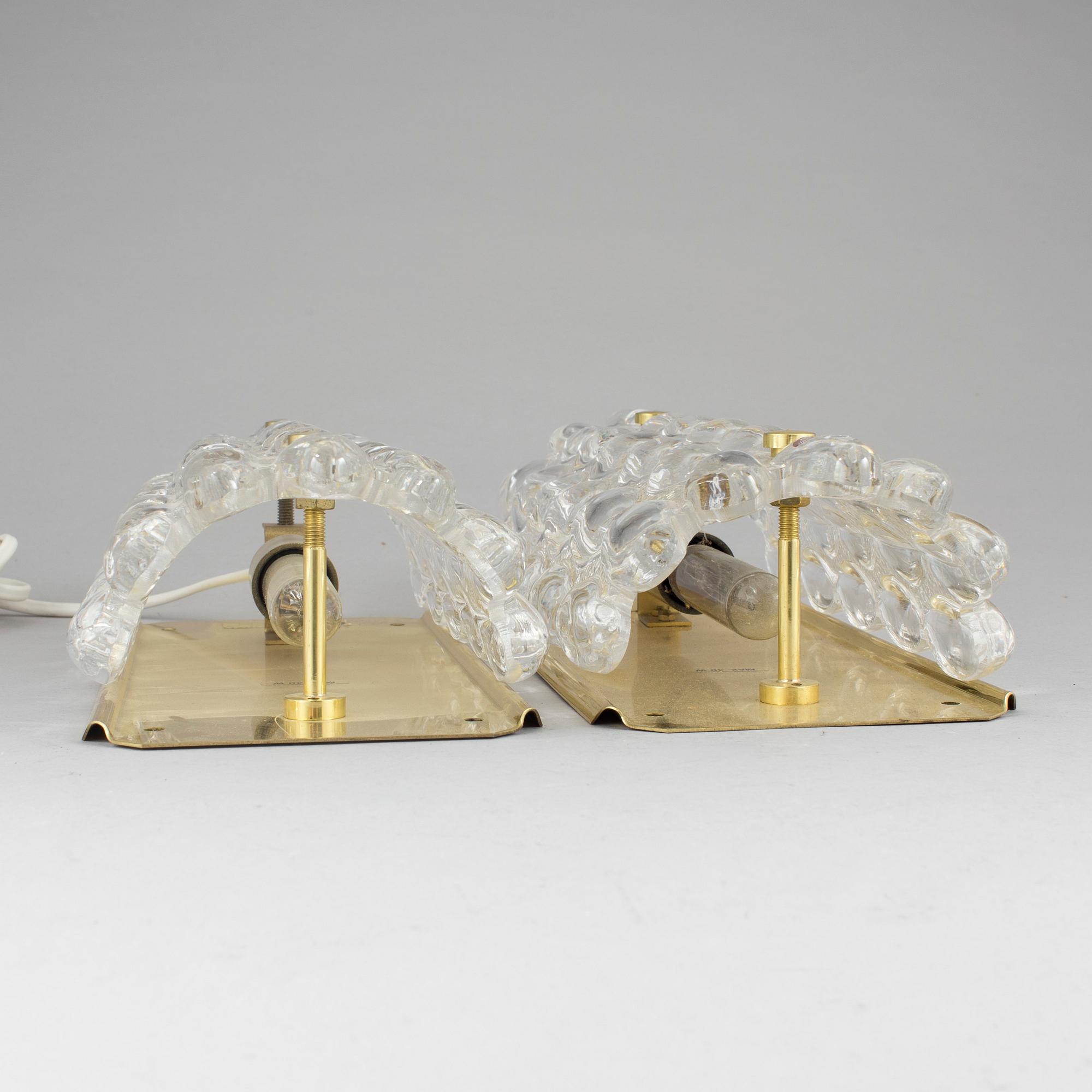 A pair of brass and glass wall lights designed by Carl Fagerlund for Orrefors.