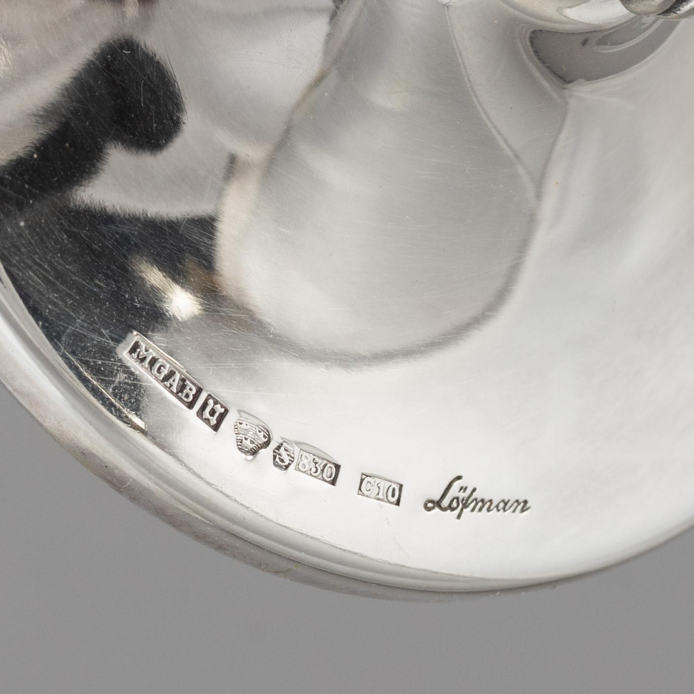 Eric Löfman, a Swedish silver candlestick, a vase and four cups, including MGAB, Uppsala 1977.