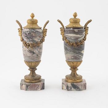 A pair of Louis XVI style urns with covers.