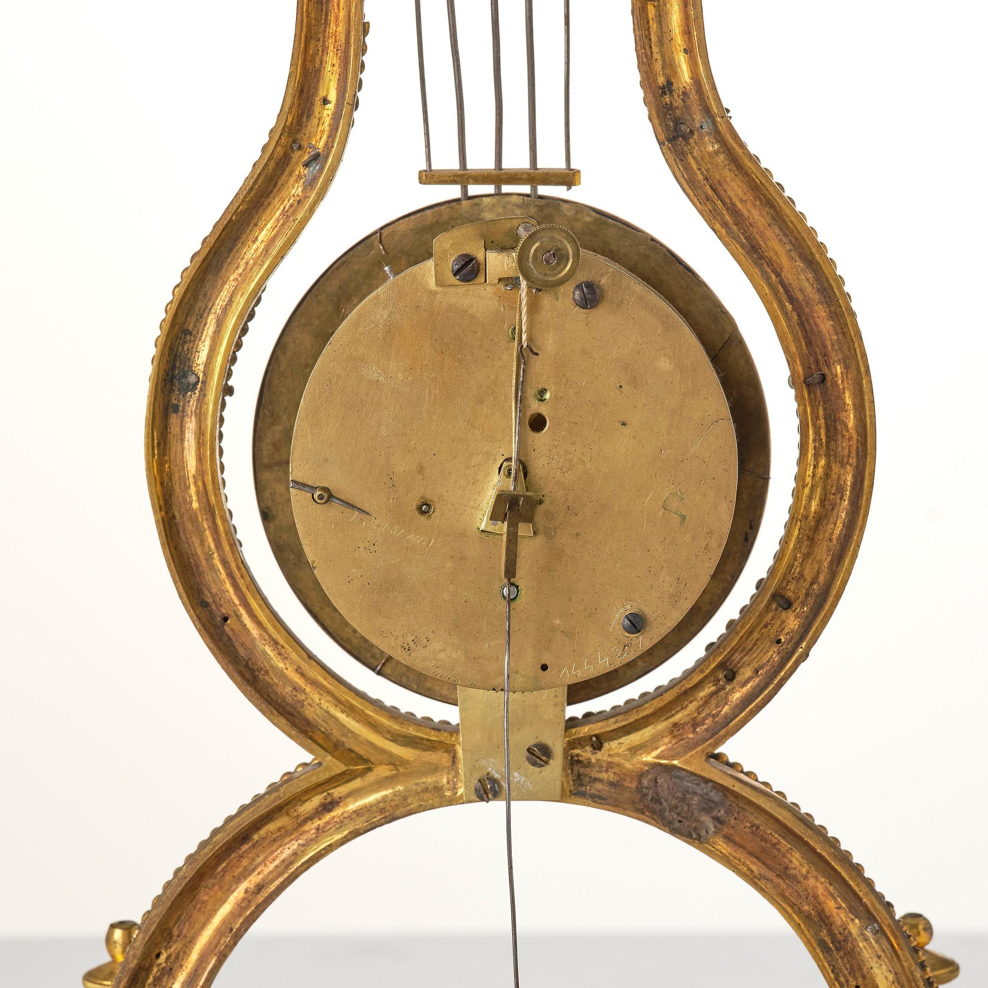 A French Louis XVI ormolu and marble lyre-shaped mantel clock, late 18th century.