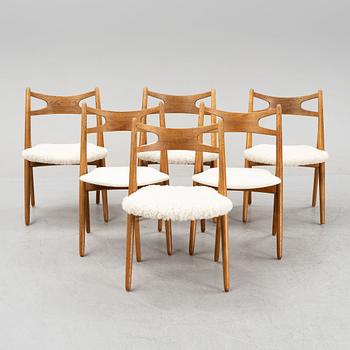 A set of six model CH 29 oak chairs by Hans J Wegner, two with leather upholstery and four with sheepskin.