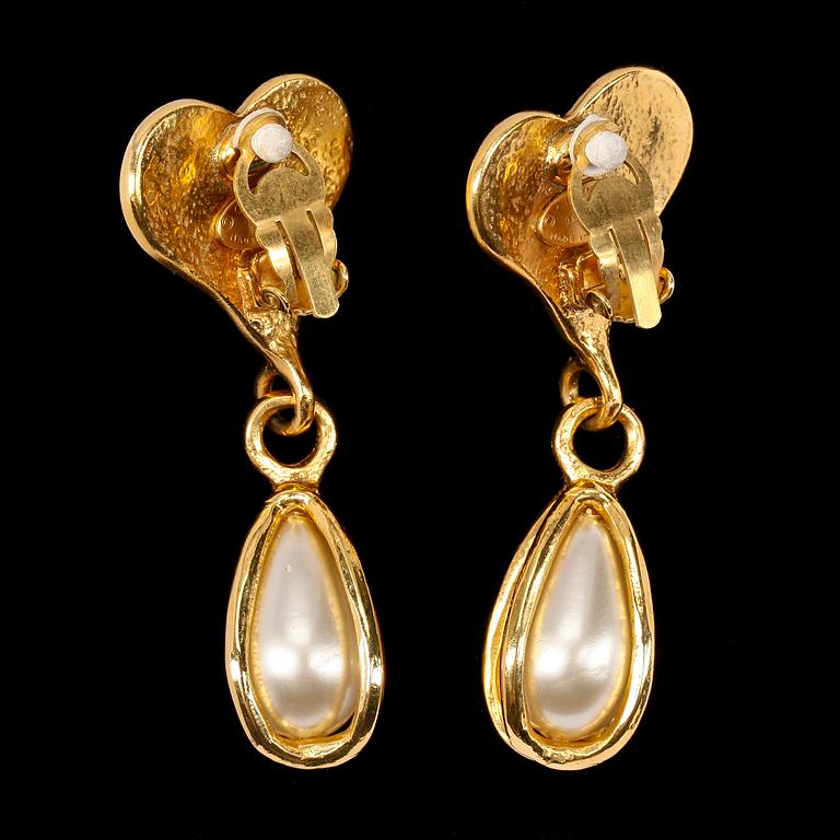 A pair of golden earclips with a decorative pearl by Chanel.