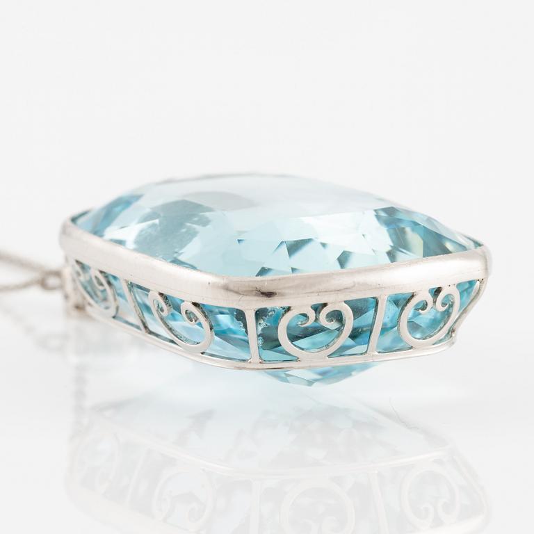 A platinum necklace with a faceted aquamarine and an oval old-cut diamond.
