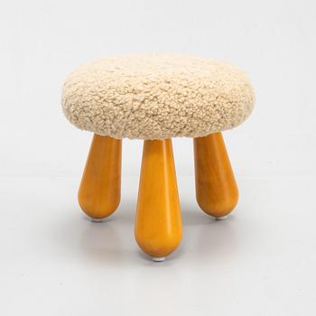 A Swedish, new produced stool with birch legs and sheepskin upholstery.