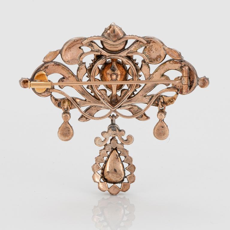 A silver brooch set with round brilliant-cut diamonds.