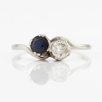 Ring, sibling ring, platinum with brilliant-cut diamond and dark sapphire.