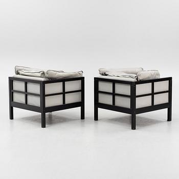 A pair of leather upholstered armchairs. End of the 20th Century.