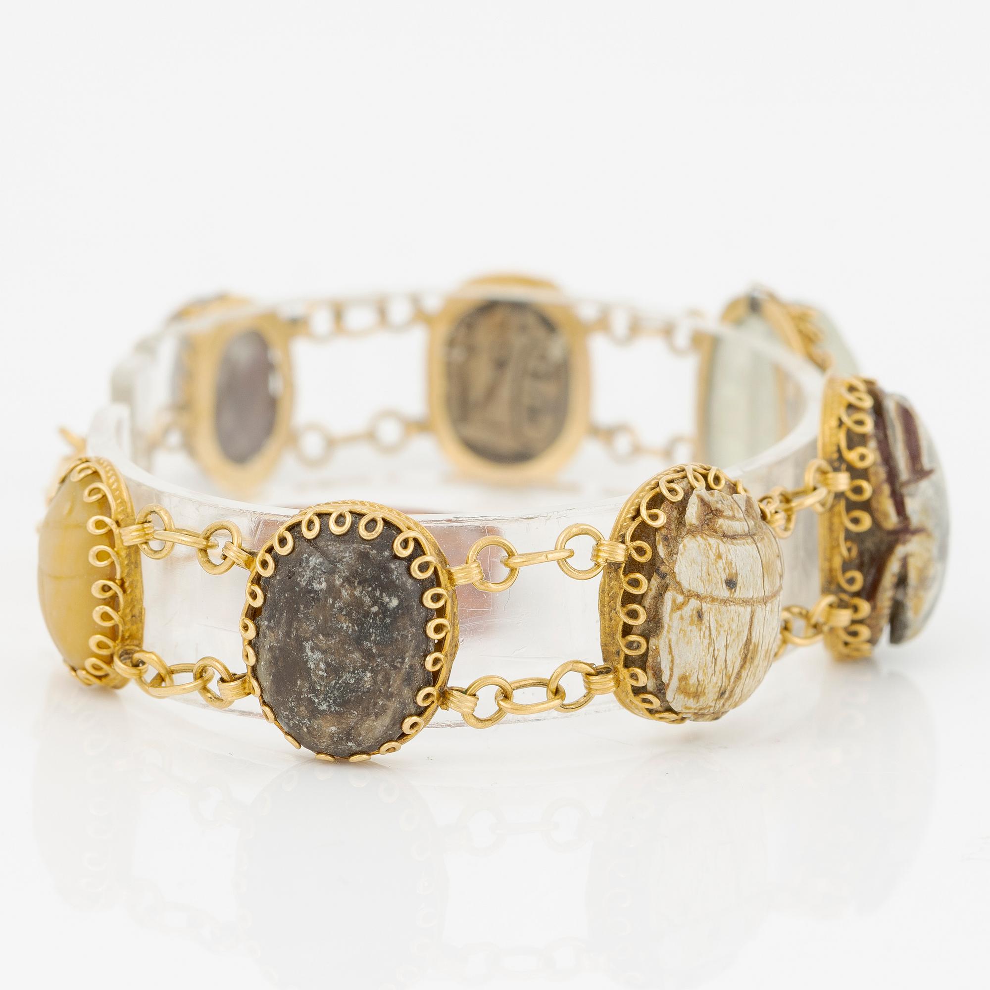 Bracelet in 14K gold with various minerals and scarab-shaped charms.