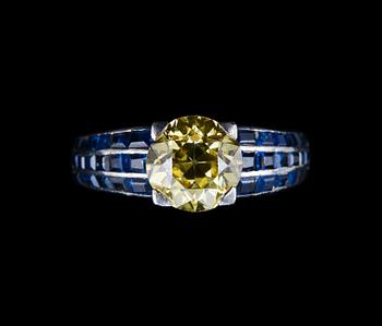 A RING, brilliant cut yellow diamond c. 2.00 ct. 36 square cut sapphires, platinum. Geneve 1950 s. Weight 9 g.