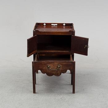 A mahogany bedside table from around the year 1900.