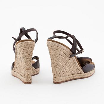 YVES SAINT LAURENT, a pair of straw and leather wedge sandals.