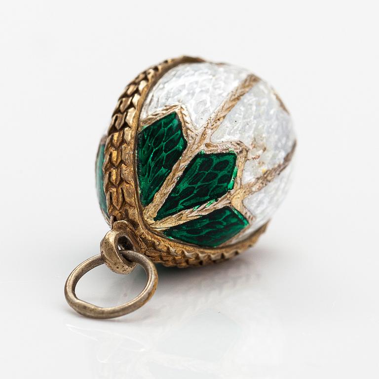 A gilded silver and enamel egg shaped pendant with a glass stone.