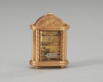 An early 20th century gold and enamel miniature clock.