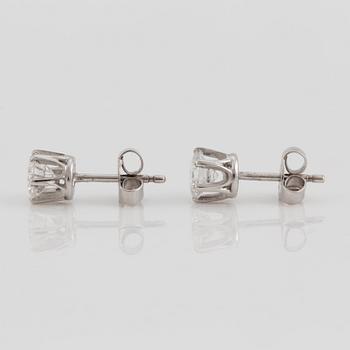 A pair of brilliant cut diamond earrings.